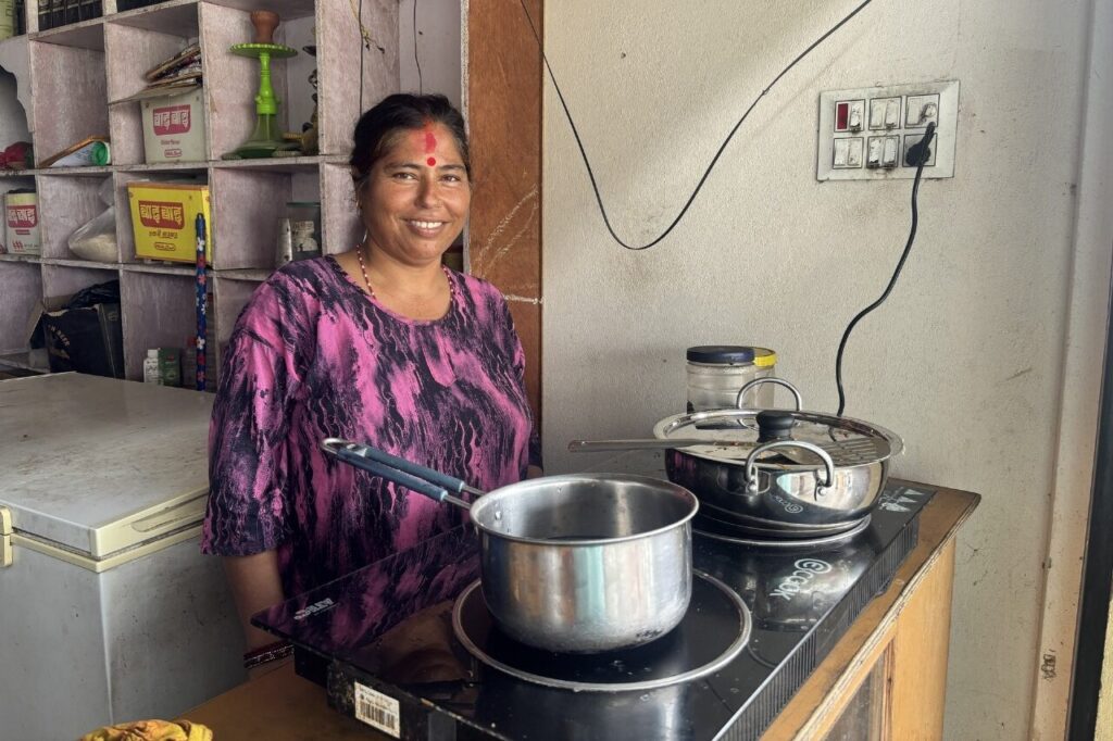 A shopkeeper standing beside electric cooking equipment