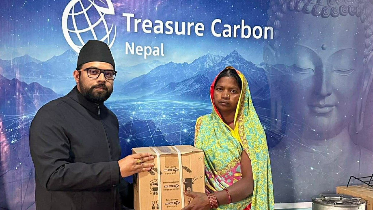 A cookstove handover in front of the Treasure Carbon Nepal banner